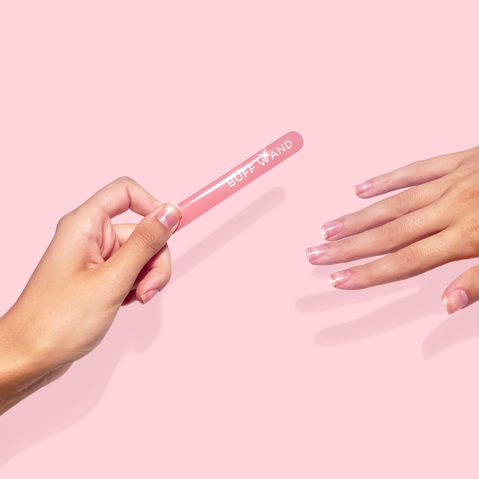 Hands holding buff wand with shiny natural nails